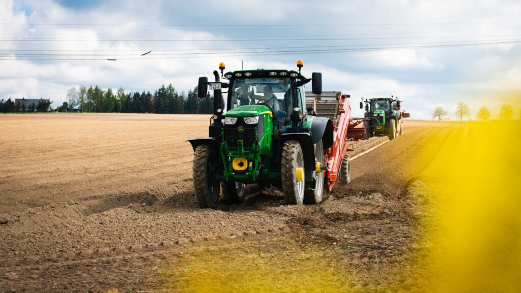 Moderne Traktoren bei der Feldbestellung auf einem Acker unter bewölktem Himmel – landwirtschaftliche Maschinen im Einsatz bei der Frühjahrsaussaat