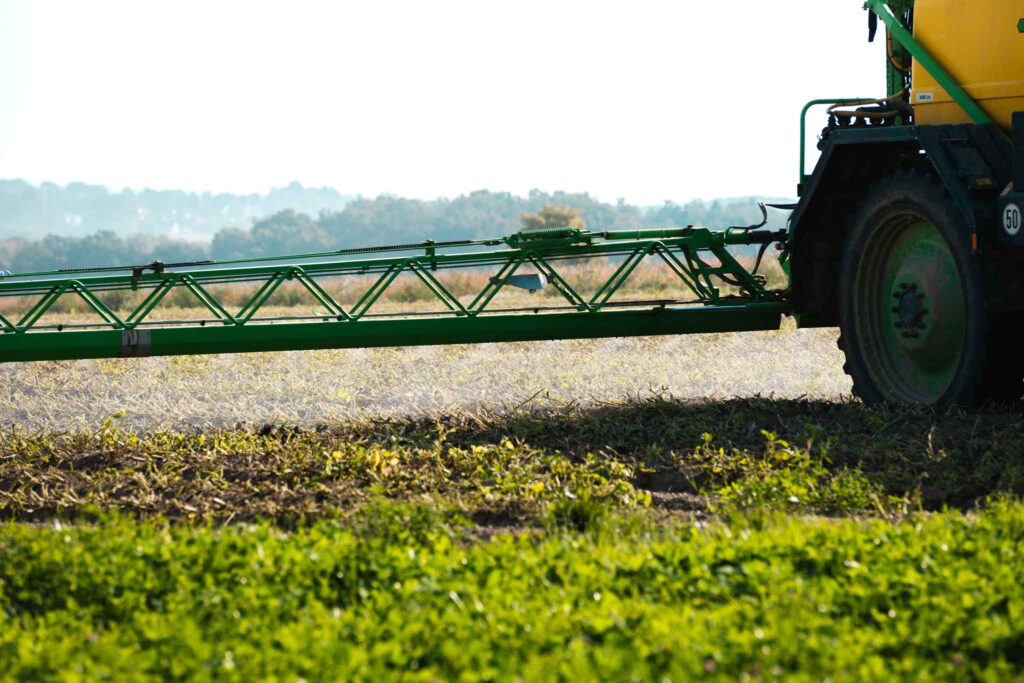 Großansicht eines landwirtschaftlichen Sprühgeräts auf einem Feld bei der Ausbringung von Pflanzenschutzmitteln.