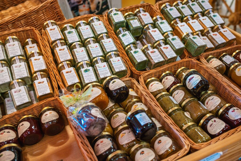 Regionale Feinkost im Friweika Werksverkauf: Vielfältige Auswahl an Gewürzmischungen, Dips und hausgemachten Marmeladen in dekorativen Weidenkörben.