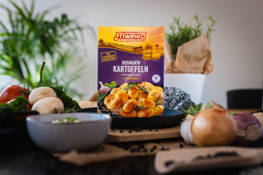 Verpackung von Friweika Rosmarinkartoffeln platziert in einer gemütlichen Küchenkulisse mit frischen Zutaten