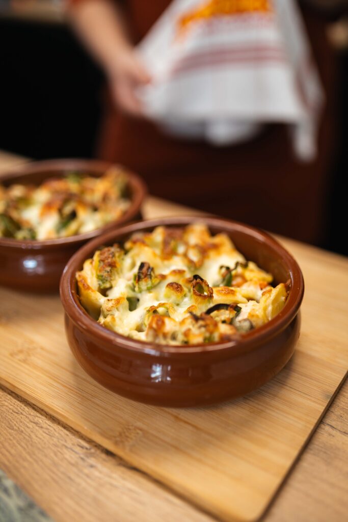 Frisch gebackenes Kartoffelgratin mit Käse überbacken in zwei Tonschalen