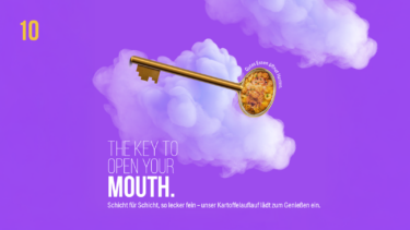 Lila Werbegrafik mit weißen Wolken und einem goldenen Schlüssel, in dessen Griff ein cremiger Kartoffelauflauf abgebildet ist. Mit dem Text „THE KEY TO OPEN YOUR MOUTH“ und einem Hinweis auf leckeren Kartoffelauflauf.