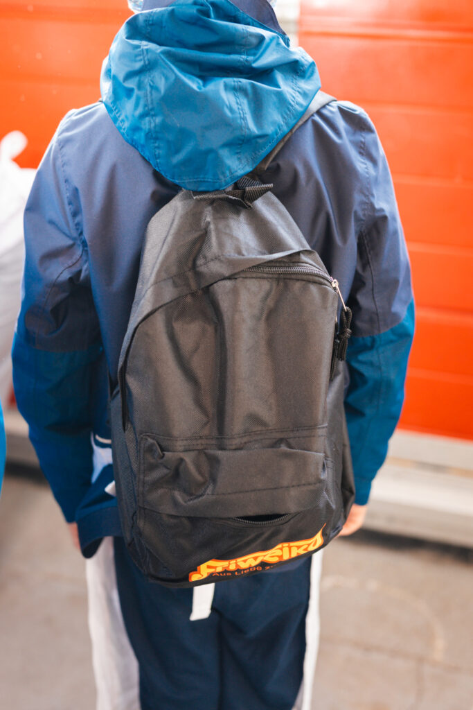 Kind von hinten mit schwarzem Friweika-Rucksack