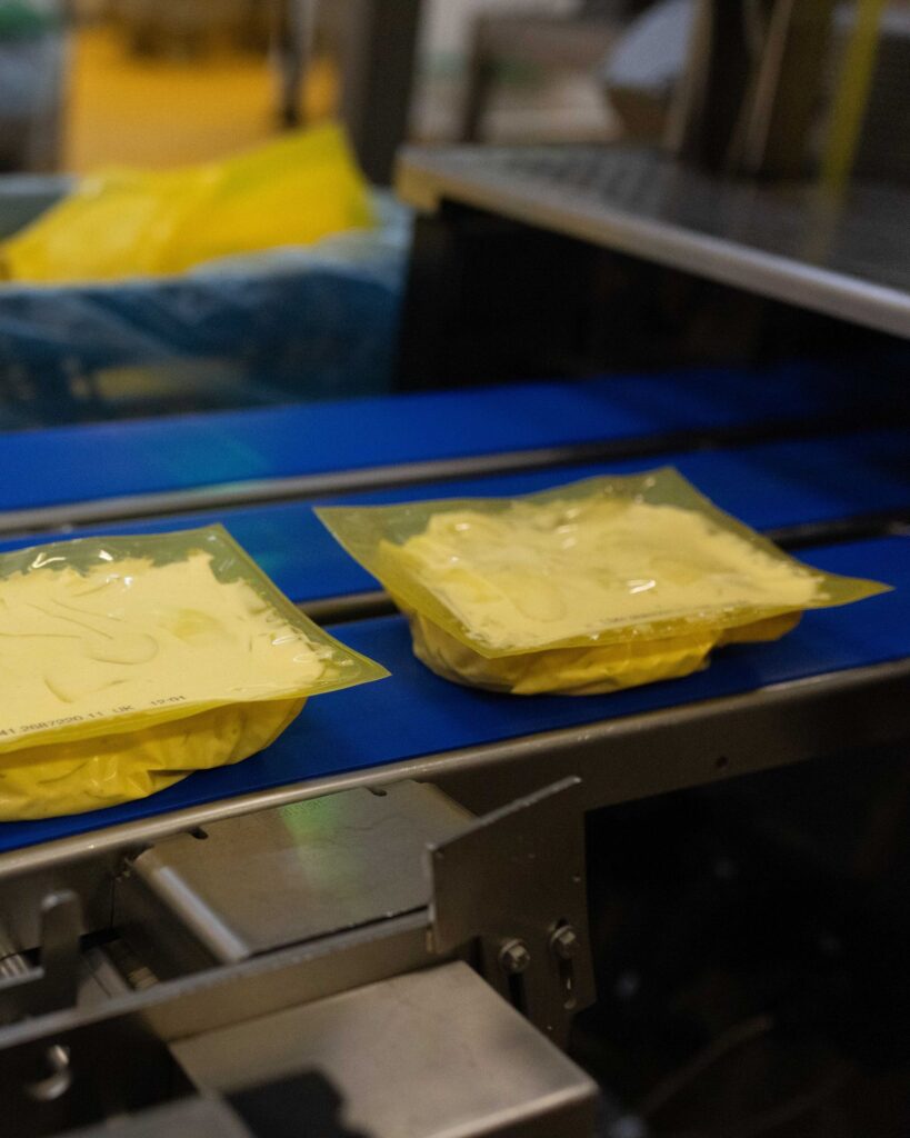 Fertig verschweißte Kartoffelgerichte in Folienschalen auf der Transportstraße